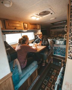 couple sitting inside of truck bed camper