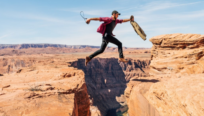 Man jumping between two rocks.