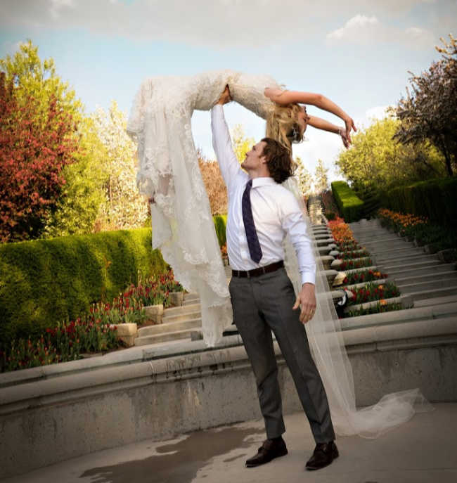 man lifting woman into air in a wedding dress