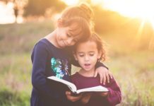 sister siblings hugging and reading scriptures out loud