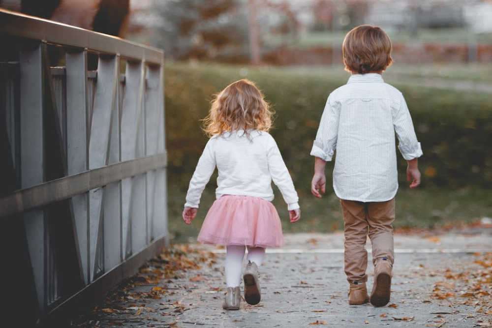 brother and sister sibling relationship walking on a bridge