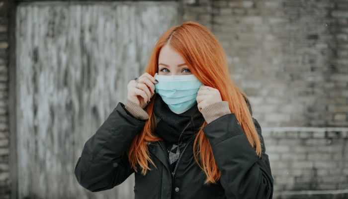 girl holding up medical mask