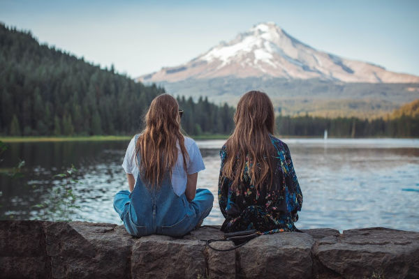 Women sitting together by a lake