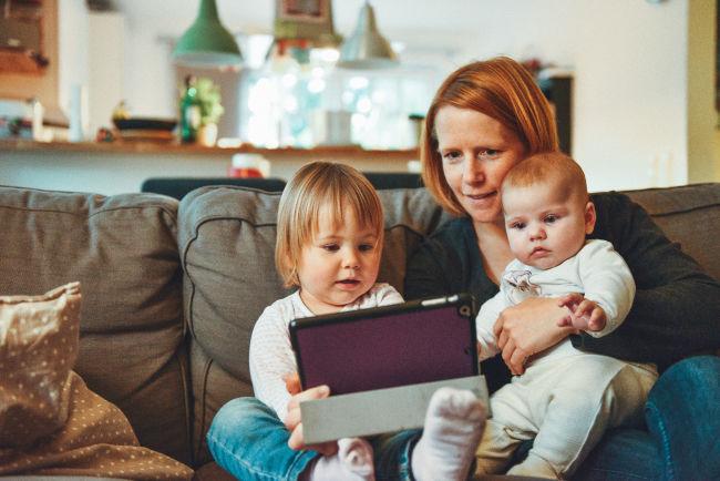 mother holding tablet with her two children
