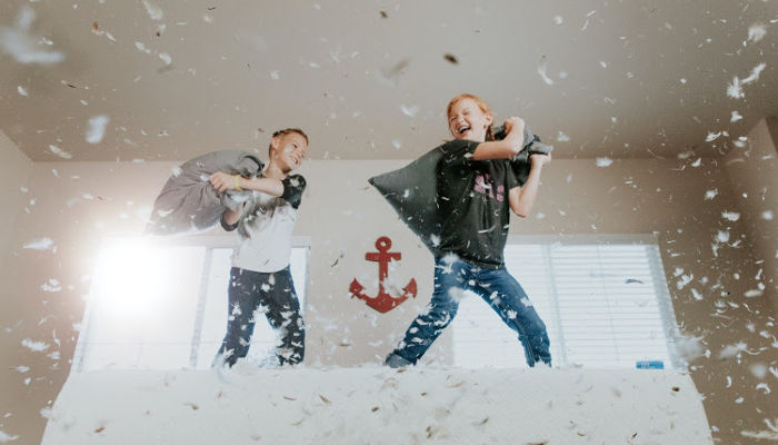 two kids pillow fighting with each other during covid-19