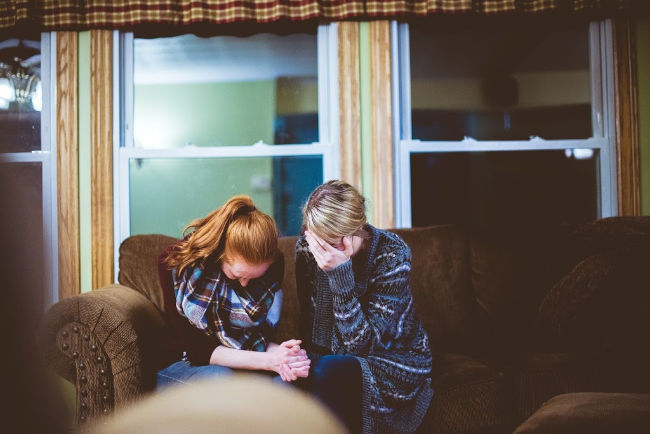 two women crying together suffering with grief