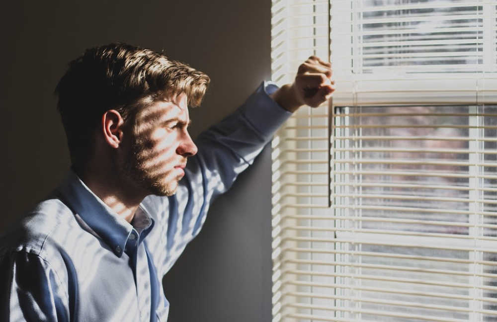 sad person looking out a window