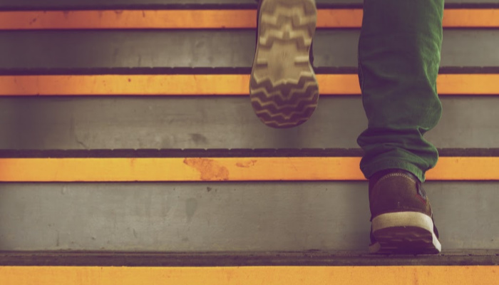 person walking up stairs wearing shoes and green pants