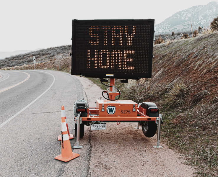 construction sign that says to stay home and quarantine
