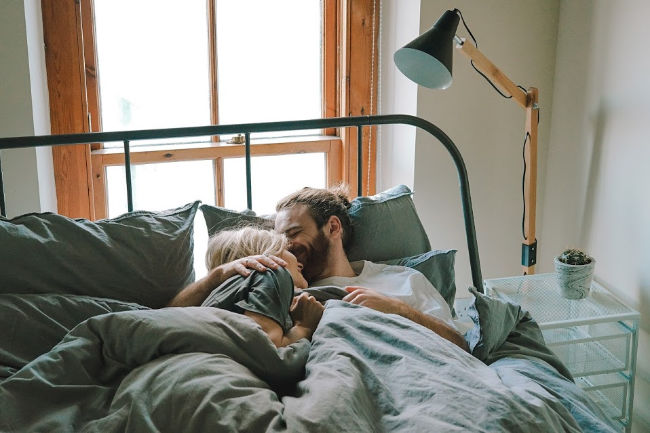 man and woman in bed on wedding night