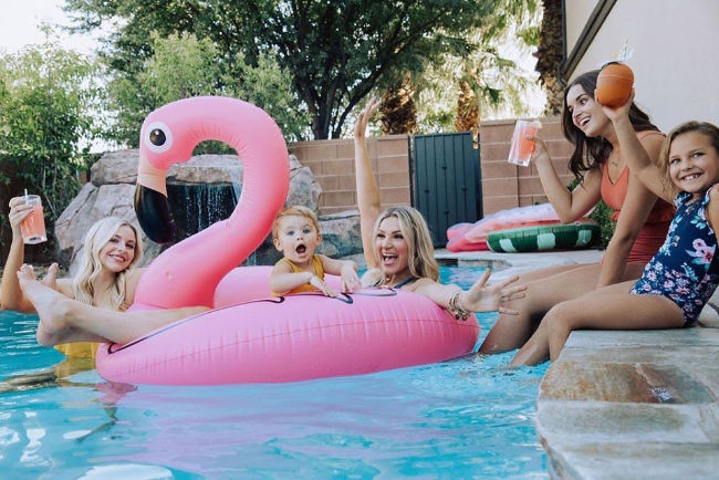 family swimming in pool wearing modest swimsuits