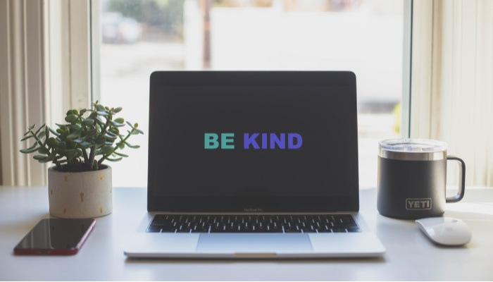 a laptop showing the words be kind