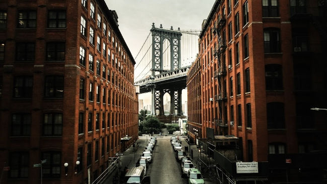 a new york city neighborhood with a bridge in the background