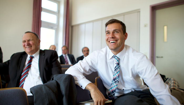 men sit together in elders quorum on sunday