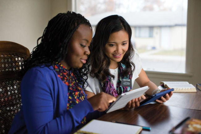 dos hermanas misioneras que estudian juntas en ipads sonriendo