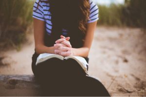 girl praying with scriptures