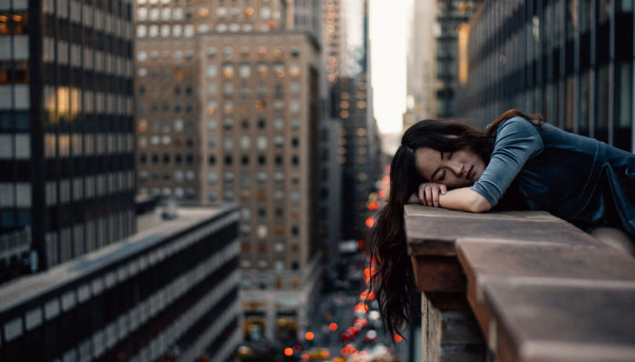 woman asleep on the side of tall building