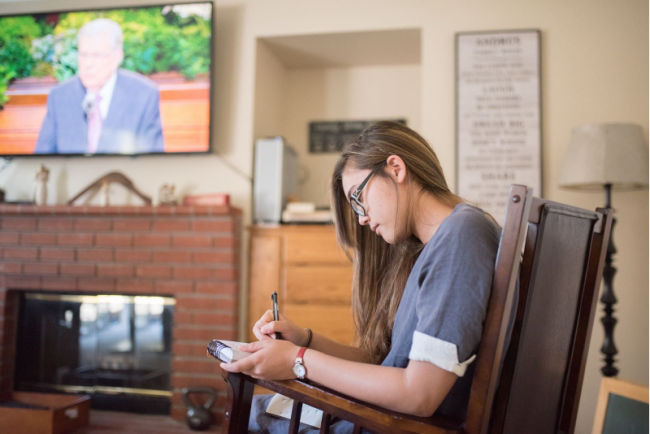 young woman listens to general conference for the church