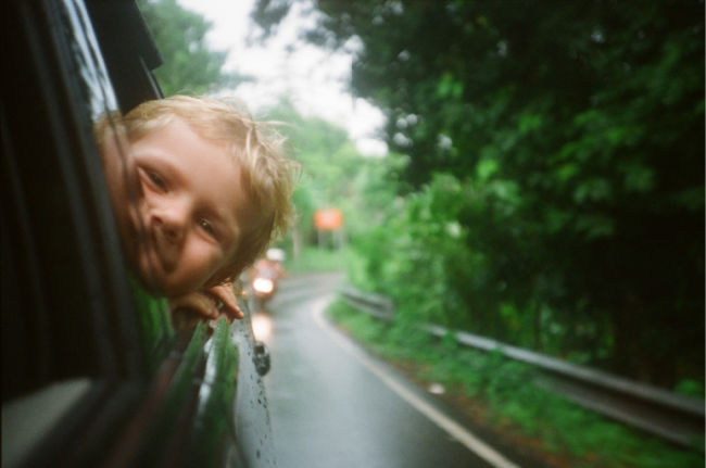 child with his head out the window while driving