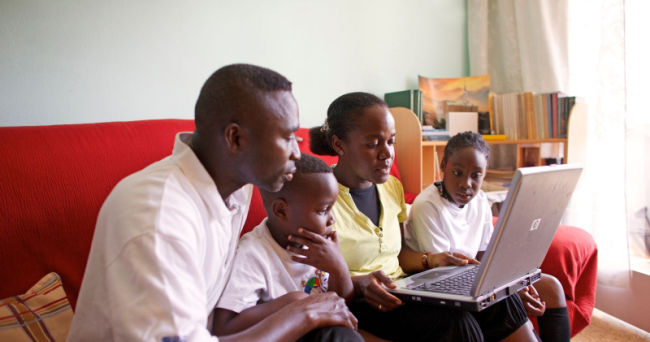 family looking at a laptop together researching