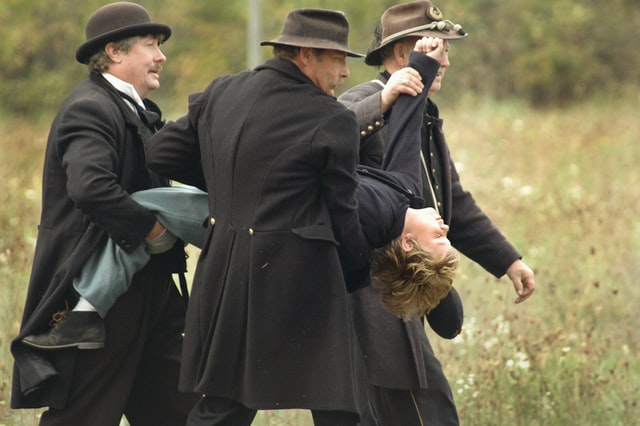 period photo men carrying boy to punishment