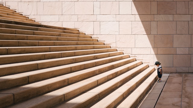 toddler at the base of huge stairs