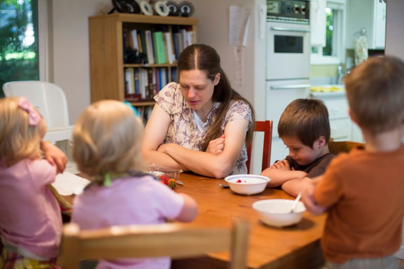 A mother and her children pray over the breakfast food.